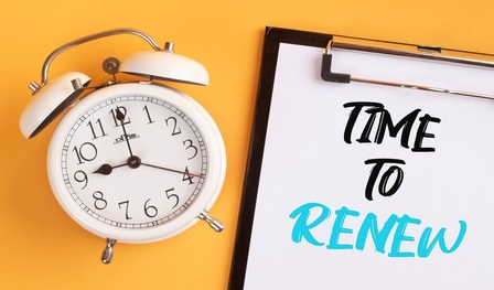 Photo of an alarm clock next to a notepad that reads "Time to Renew"