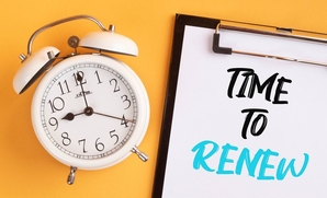 Photo of an alarm clock next to a notepad that reads "Time to Renew"